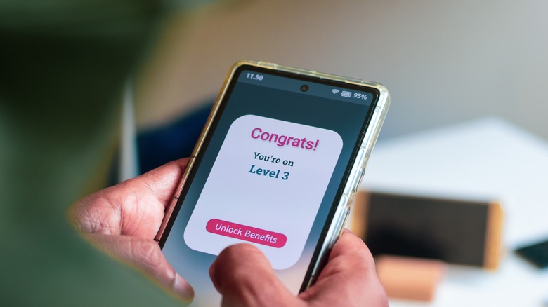 Person holding phone with rewards app