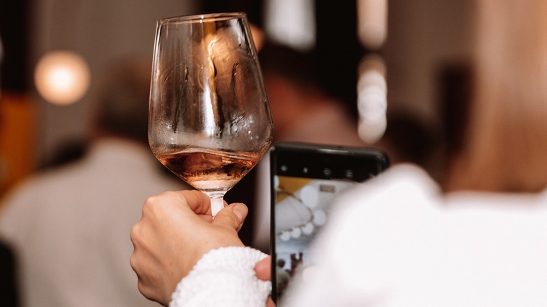 Person holding up a glass of wine in a restaurant