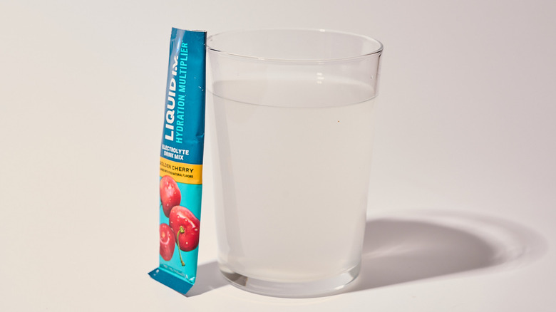 Golden Cherry Liquid I.V. next to a glass of water