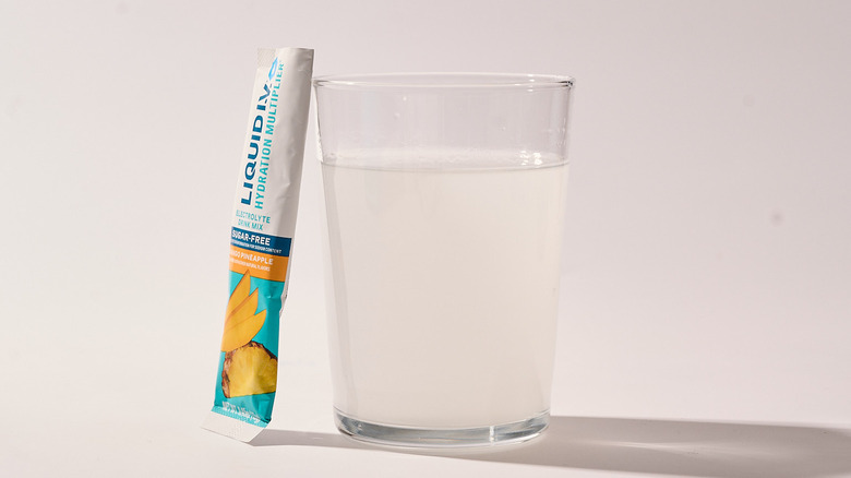 Mango Pineapple Liquid I.V. next to a glass of water