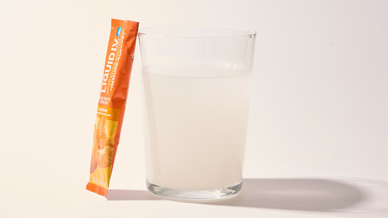 Tangerine Liquid I.V. next to a glass of water