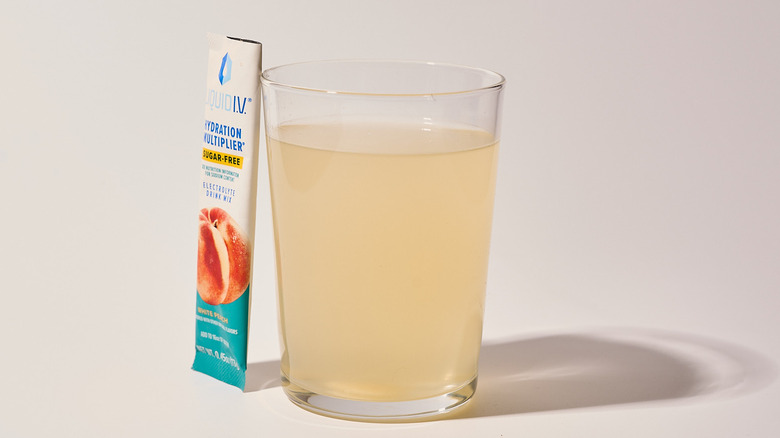 White Peach Liquid I.V. next to a glass of water