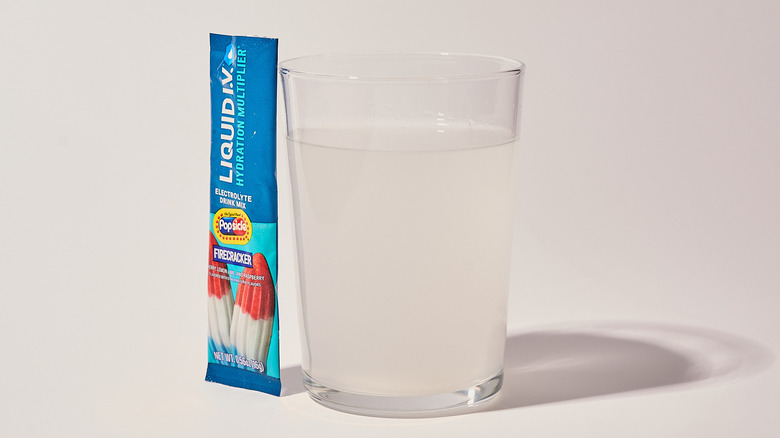Popsicle Firecracker Liquid I.V. next to a glass of water