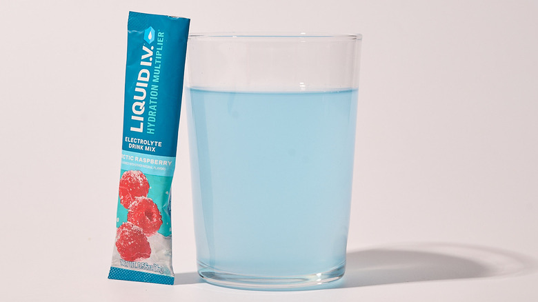 arctic raspberry liquid i.v. packet on a table with a glass