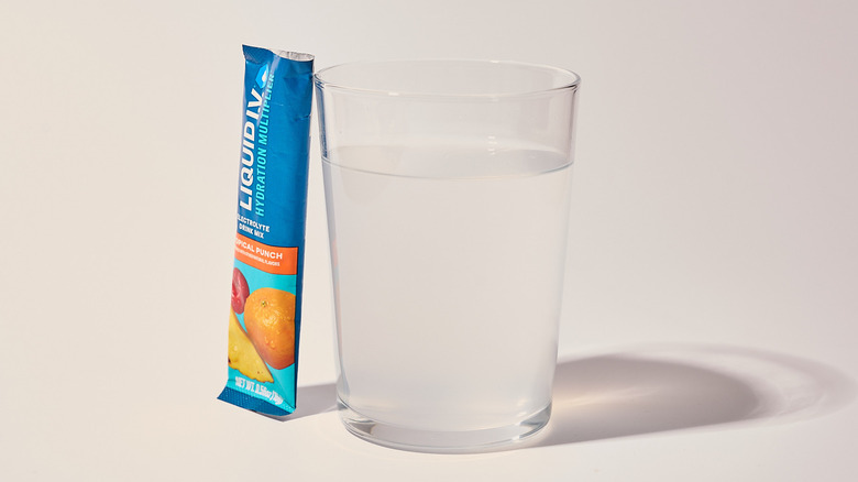 Tropical Punch Liquid I.V. next to a glass of water