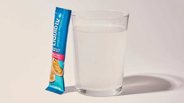 Passion Fruit Liquid I.V. next to a glass of water