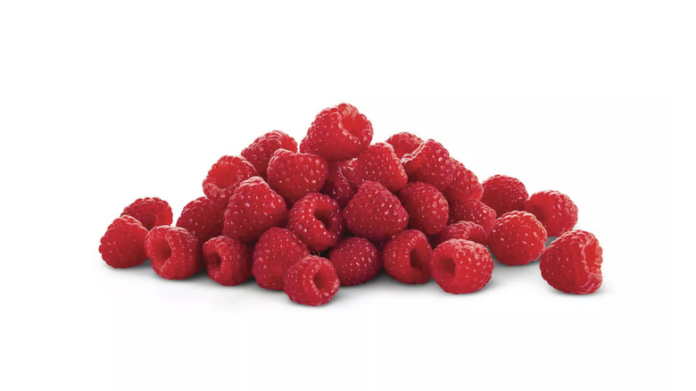 A pile of fresh raspberries on a white background
