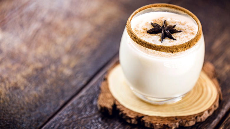 Glass of coquito, garnished with star anise