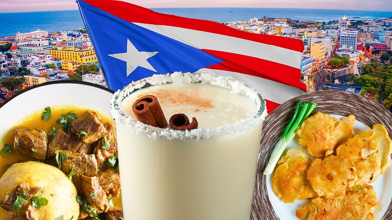 Glass of coquito, plate of mofongo, and plate of bacalaitos in front of a Puerto Rican flag