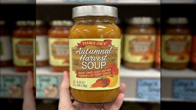 Person's hand holding up a jar of Trader Joe's Autumnal Harvest Soup