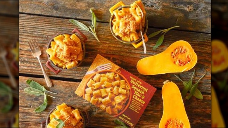 Box of Butternut Squash Mac & Cheese surrounded by bowls filled with cooked mac and cheese