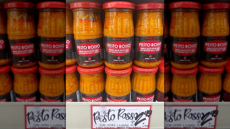 Multiple jars of Trader Joe's Pesto Rosso sauce on shelf in stores.