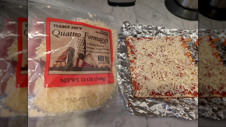 Bag of quattro formaggio shredded cheese from trader joe's next to pizza on foil.