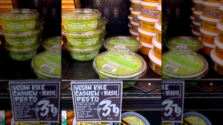 Multiple containers of Trader Joe's Vegan pesto on shelf in stores.