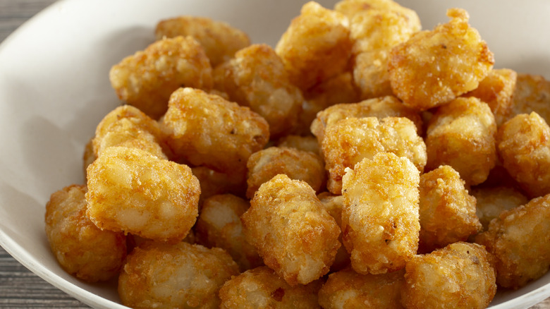 Tater tots in a white bowl.