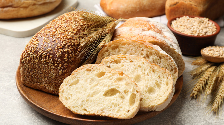 A plate of rustic bread, some sliced some whole