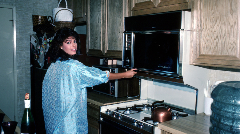 Person from the 1980s using a microwave