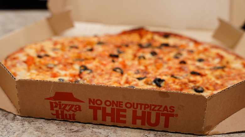 A Pizza Hut pizza in a takeout box
