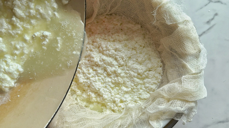 pot of curds being poured into colander