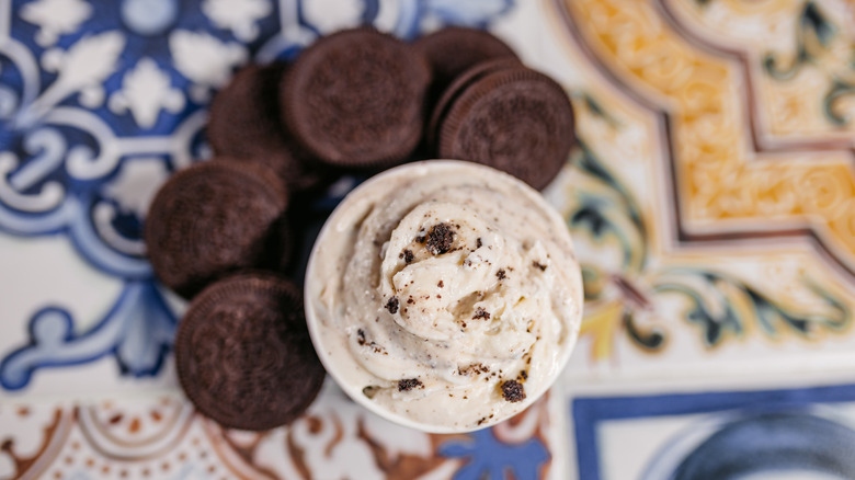 a cup of cookie ice cream surrounded by oreos