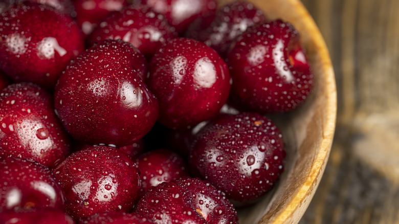 A bowl of wet cherries on a kitchen table.