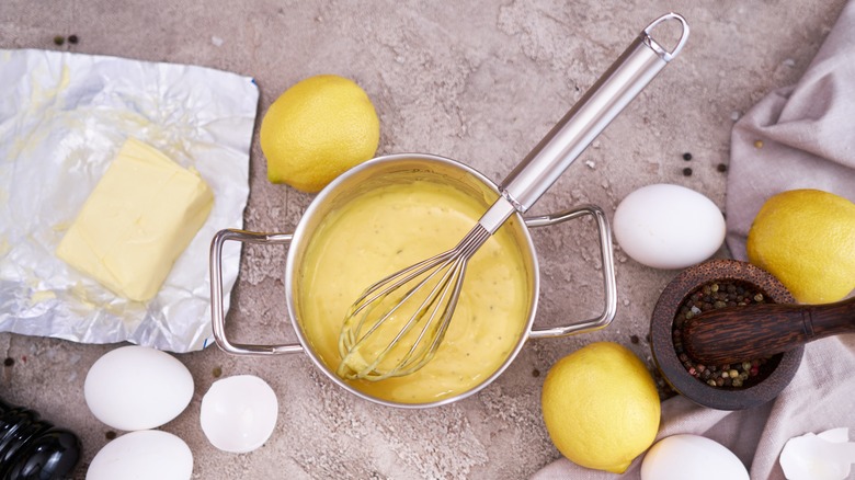 making hollandaise sauce with the ingredients surrounding the pot