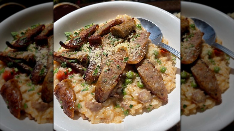 White bowl of Tuscan Sausage Risotto with Peas and Roasted Grape Tomatoes