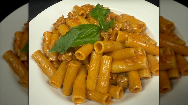 Plate of rigatoni with vodka sauce garnished with fresh basil