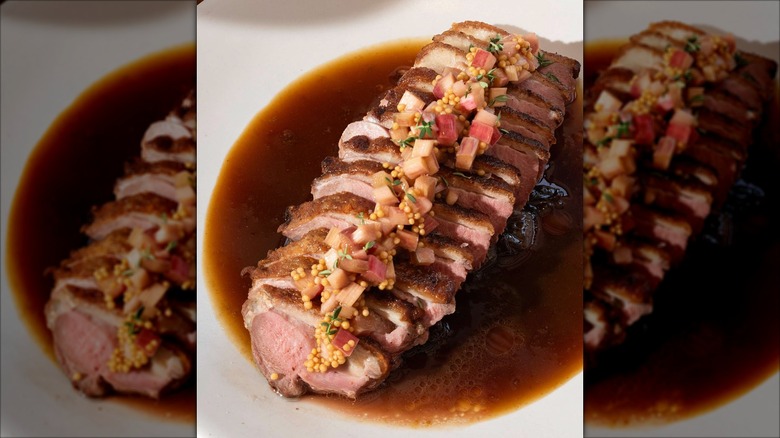 Plate of sliced duck breast in broth
