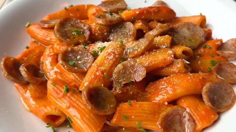 White bowl of rigatoni with sausage vodka sauce