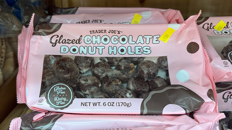 A pink box of chocolate donut holes on a shelf