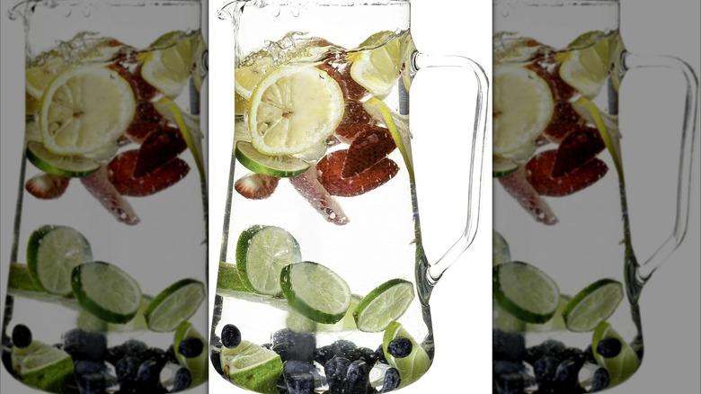 The top of a glass pitcher with lemon wheels in close-up.
