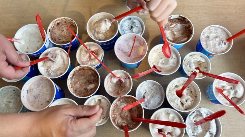 Dairy Queen Blizzards arranged on table with hands reaching in