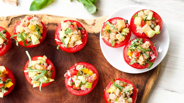 Bite-Sized Panzanella Stuffed Tomatoes on a small plate and a wooden board