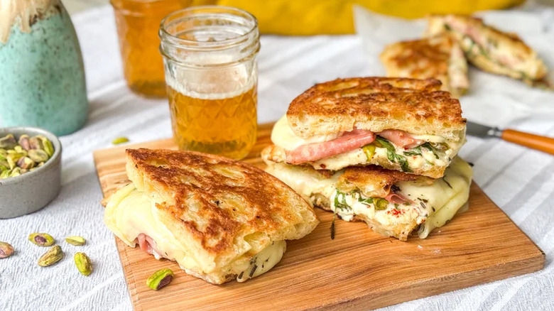Grilled Italian Picnic Sandwich served on a wooden board with a drink in a mason jar