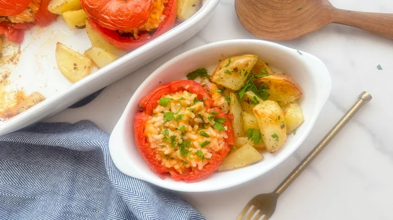 Pomodori Con Riso (Roman Baked Stuffed Tomatoes) in a white serving dish