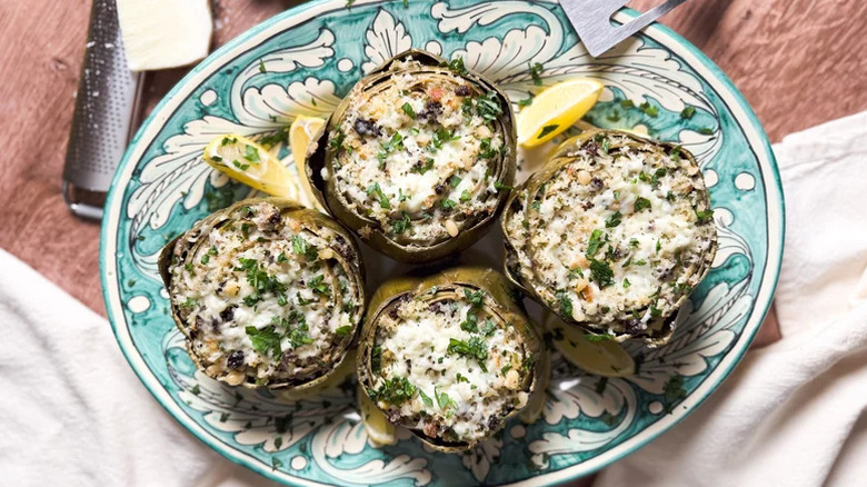 Sicilian-Style Stuffed Artichokes served with lemon wedges