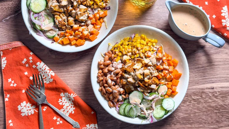 Two servings of 'BBQ In A Bowl' Chicken Salad with a dish of freshly made dressing