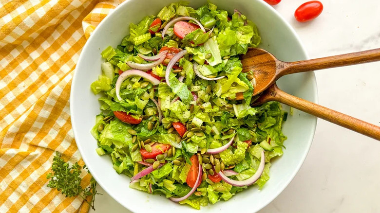 Green salad in a bowl with yellow towel