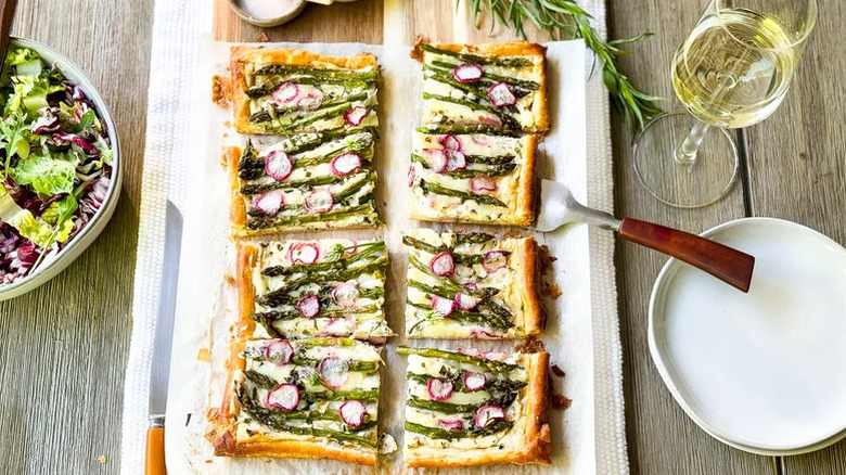 Tray of asparagus tarts with wine glass