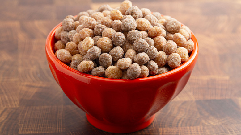 Reese's Puffs in an orange bowl on a wood surface