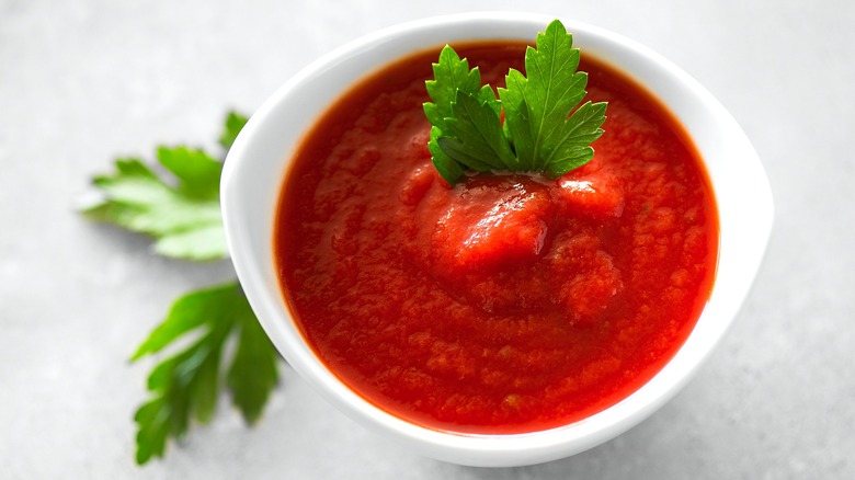 Small bowl of tomato sauce with Italian flat-leaf parsley