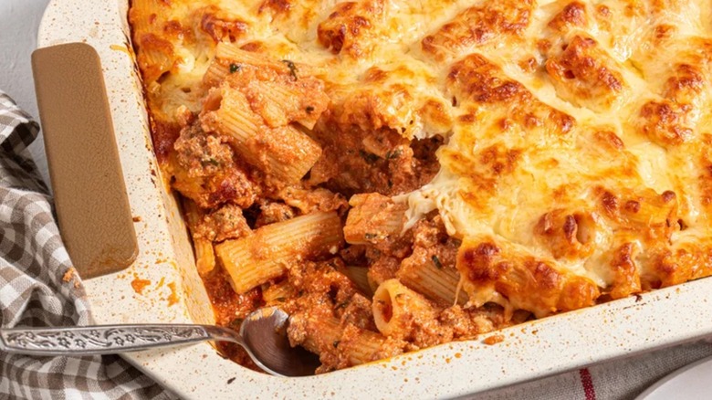 Tray of baked ziti with a spoon