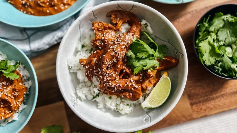 Bowl of chicken mole with rice and lime