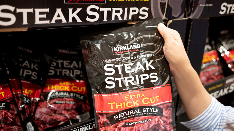 Kirkland Signature Premium Extra Thick Steak Strips held up by hand