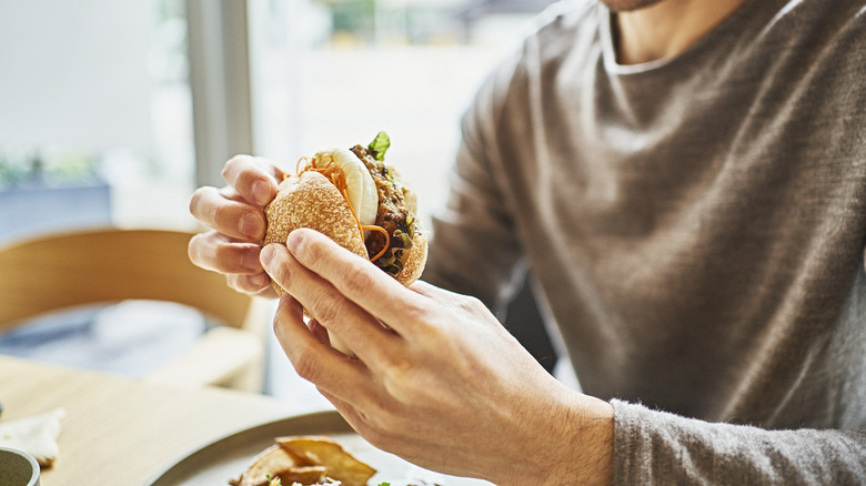 Man eating a sandwich with his hands at a restaurant