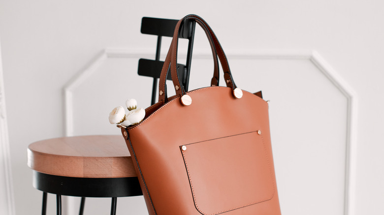 Brown women's bag hanging from a chair