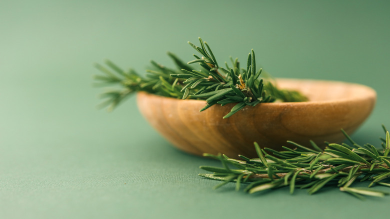 Wooden bowl of fresh rosemary sprigs