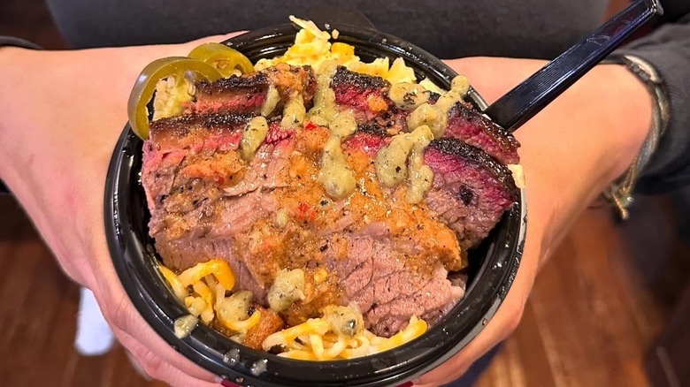 A person holding a bowl of barbecued meats at Dayne's Craft BBQ