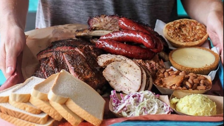 A tray with brisket, sausage, ribs, sides and bread at Franklin BBQ